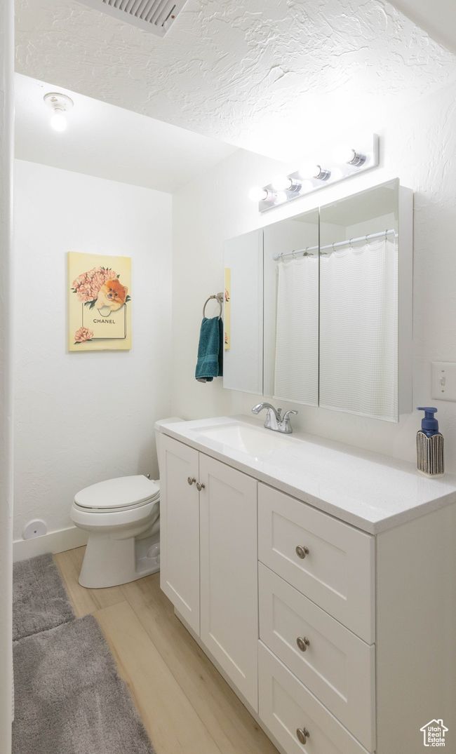 Full bathroom with wood finished floors, vanity, and toilet | Image 7