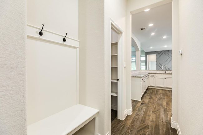 The pantry mudroom area and entrance to the three-car tandem garage are accessible through the kitchen. | Image 23