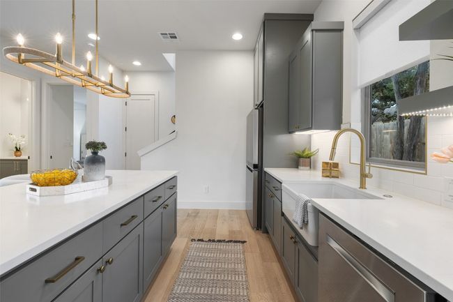 Kitchen with visible vents, decorative backsplash, light countertops, gray cabinetry, and light wood-style floors | Image 12