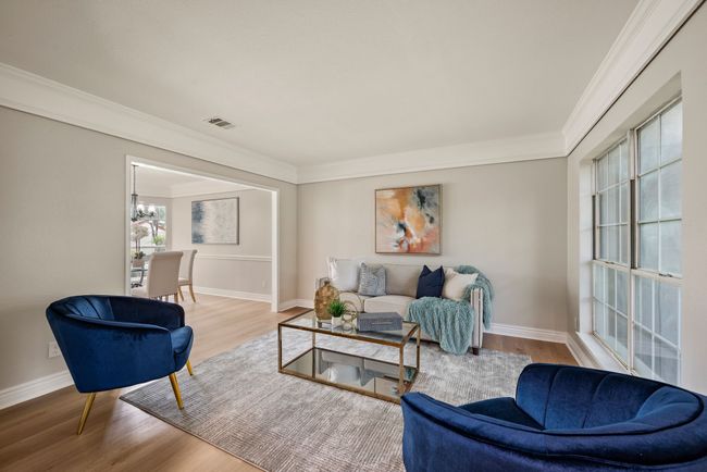 In the living room, you'll find that crown molding and neutral walls give the space a polished look. | Image 7