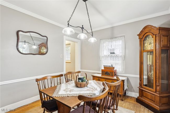 Dining area with light wood-style flooring, baseboards, and ornamental molding | Image 9