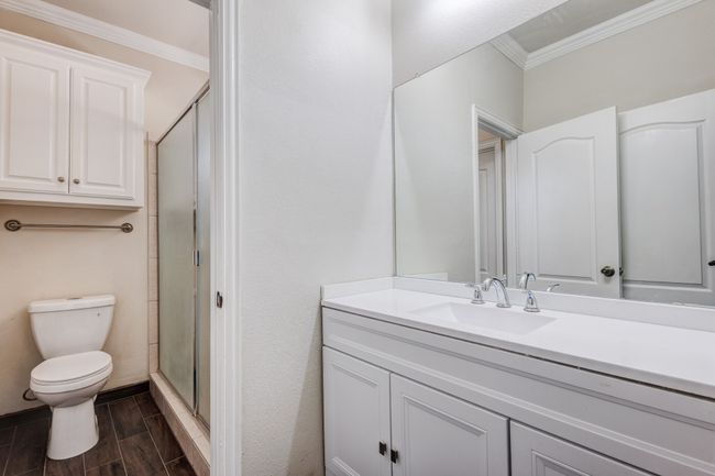 Bathroom featuring vanity, toilet, ornamental molding, and walk in shower | Image 10