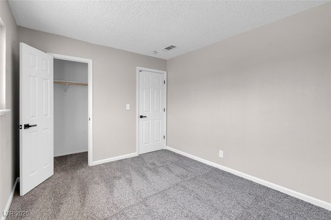 Unfurnished bedroom featuring a textured ceiling, a closet, carpet, baseboards, and visible vents | Image 31