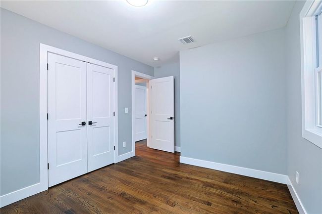 Unfurnished bedroom featuring dark hardwood / wood-style flooring and a closet | Image 15