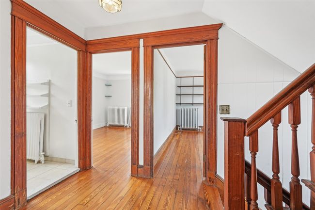 Hall featuring radiator, hardwood / wood-style flooring, and lofted ceiling | Image 25