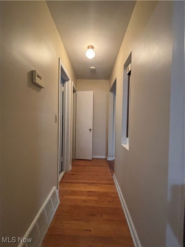 Hall featuring baseboards, visible vents, and light wood finished floors | Image 7