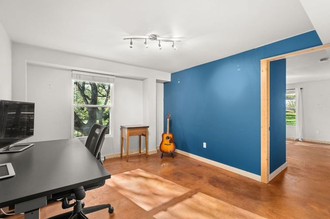 Home office featuring concrete flooring, adjacent to the fourth bedroom on the lower level | Image 24