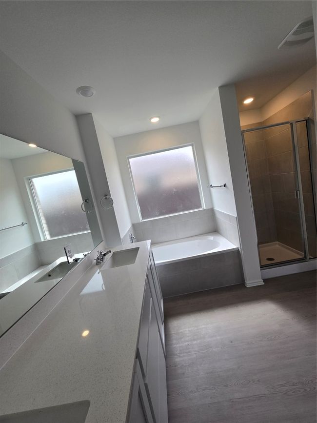 Bathroom featuring healthy amount of natural light, a garden tub, vanity, a stall shower, and recessed lighting | Image 18