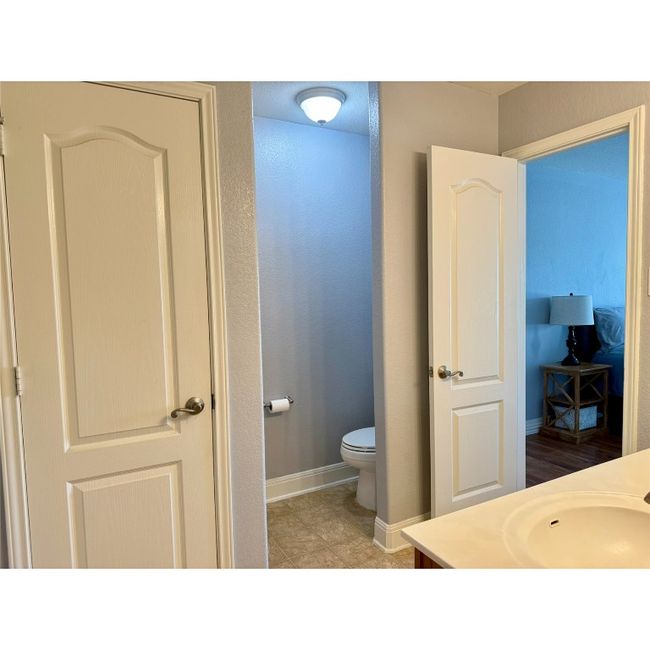 Large primary bathroom with two walk-in closets, two separate vanities, large garden tub and shower combo, toilet area | Image 25