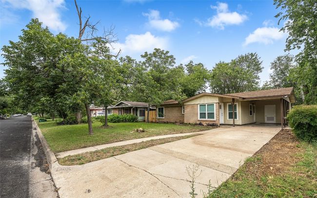 Ranch-style home featuring concrete driveway, a front lawn, brick siding, and a carport | Image 13