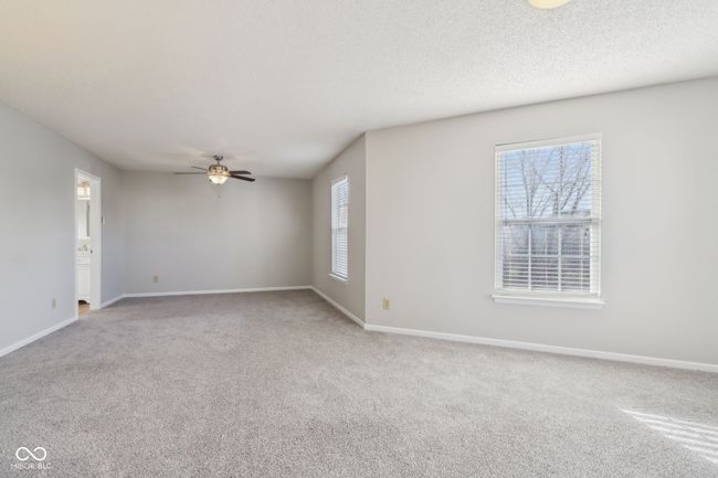 carpeted spare room featuring a ceiling fan, baseboards, and a textured ceiling | Image 35