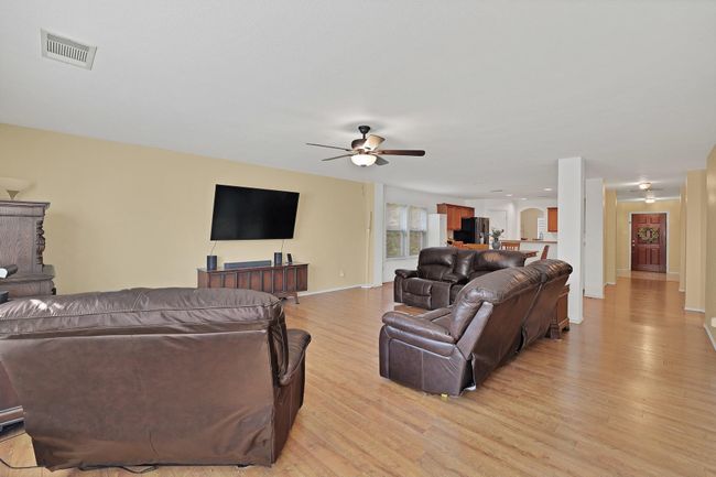 Living area with light wood-style floors and ceiling fan | Image 5