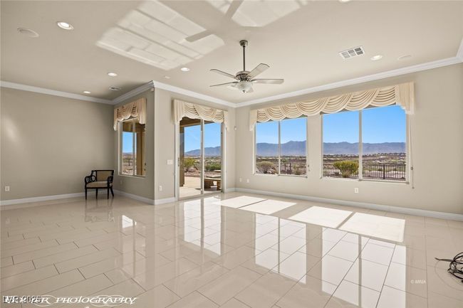 Spare room featuring visible vents, a mountain view, light tile patterned floors, a ceiling fan, and crown molding | Image 28