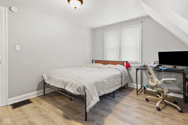 bedroom with vaulted ceiling, wood finished floors, visible vents, and baseboards | Image 7