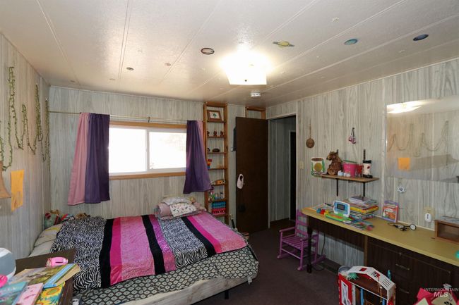 Carpeted bedroom featuring wooden walls | Image 16