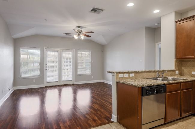 Kitchen view to family room, open floor plan, ceiling fan, and vaulted ceiling | Image 10