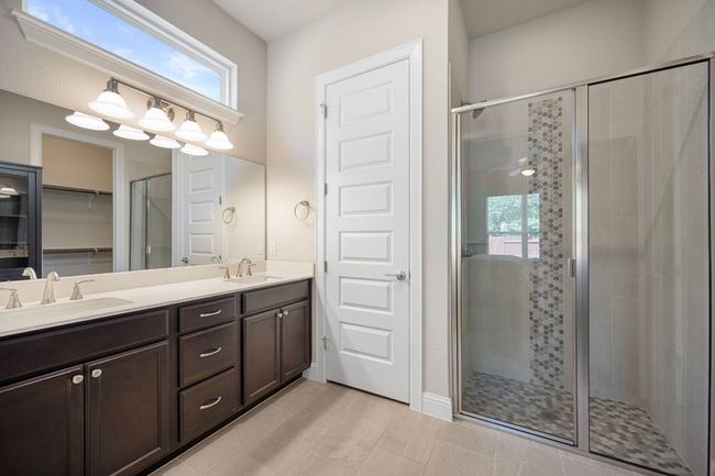 Full bathroom with a shower stall, double vanity, and plenty of natural light | Image 15