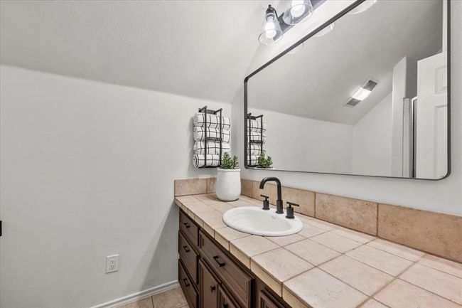 Another sleek bathroom with a large vanity, framed mirror, and neutral tilework—easy to style and move-in ready. | Image 34