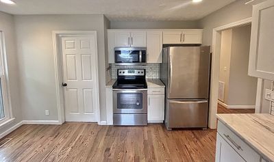 This roomy eat-in kitchen was totally renovated in 2018 offering new shaker cabinets, stainless steel appliances, & quartz countertops | Image 2