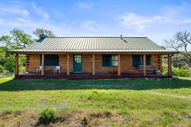 View of front of property featuring a porch, metal roof, a front lawn, and log siding | Image 6