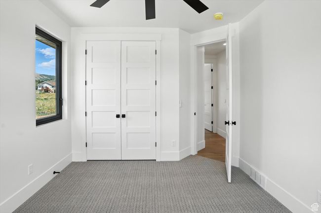 Unfurnished bedroom featuring carpet floors, a closet, and ceiling fan | Image 23