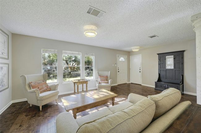 Living area featuring wood-type flooring and a textured ceiling | Image 4