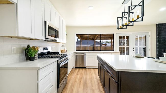 Kitchen featuring french doors, light countertops, decorative backsplash, and appliances with stainless steel finishes | Image 11