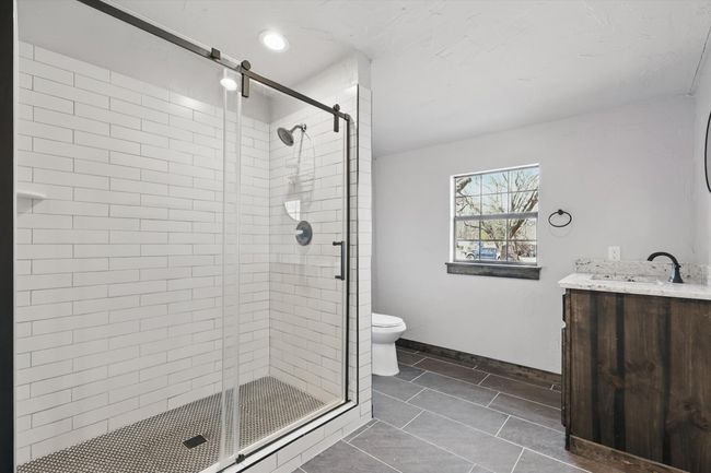 Bathroom featuring a stall shower, toilet, vanity, and baseboards | Image 20