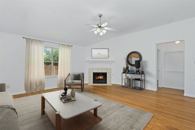 Living room featuring a tile fireplace, a ceiling fan, light wood-type flooring, and vaulted ceiling | Image 8