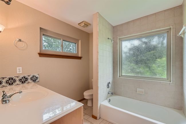 Full bath featuring vanity, tile patterned floors, and shower / tub combination | Image 18
