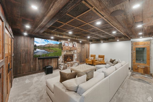 Living area featuring carpet floors, a stone fireplace, and wooden walls | Image 37