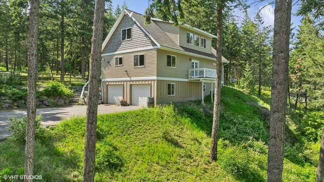 View of side of home featuring driveway, a garage, a balcony, and a shingled roof | Image 50