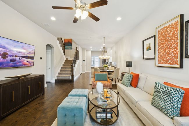 Living room with wood finished floors, stairway, recessed lighting, ceiling fan, and a chandelier | Image 8