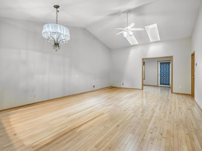 The spacious living room/ dining room boasts vaulted ceilings, two skylights, and beautiful hardwood floors. | Image 7