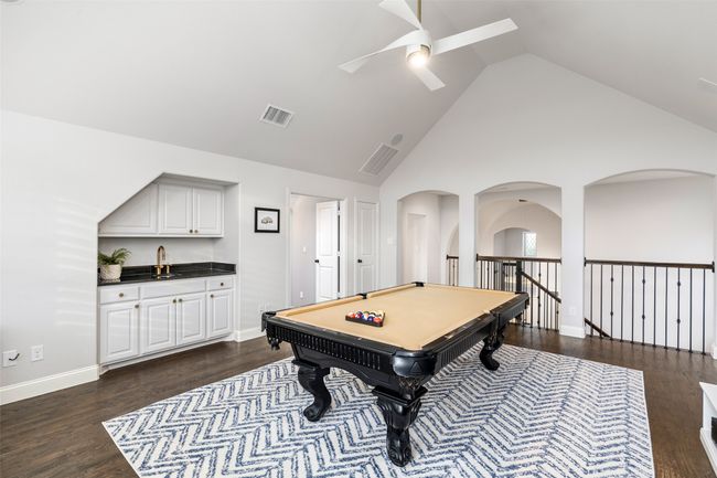 This game room is open to down stairs with the hand scraped hardwoods continuing on this second floor. Wet bar and vaulted ceiling really enhance this space. Pool anyone? | Image 25