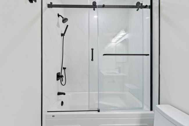 Full bathroom with combined bath / shower with glass door and toilet | Image 16