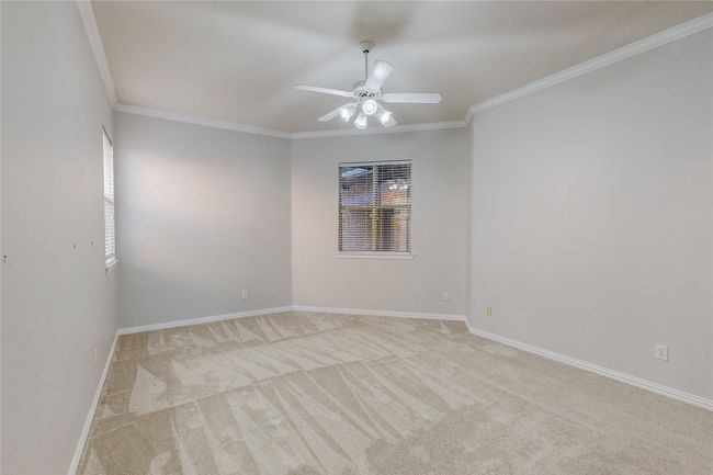 Empty room with light colored carpet, ceiling fan, ornamental molding, and baseboards | Image 21