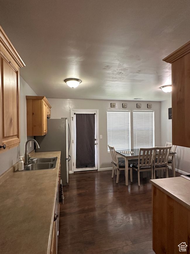Kitchen with light brown cabinetry, light countertops, a sink, dark wood-type flooring, and baseboards | Image 7