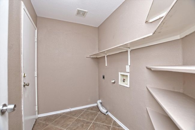 Washroom with hookup for an electric dryer, hookup for a washing machine, tile patterned floors, baseboards, and gas dryer hookup | Image 14