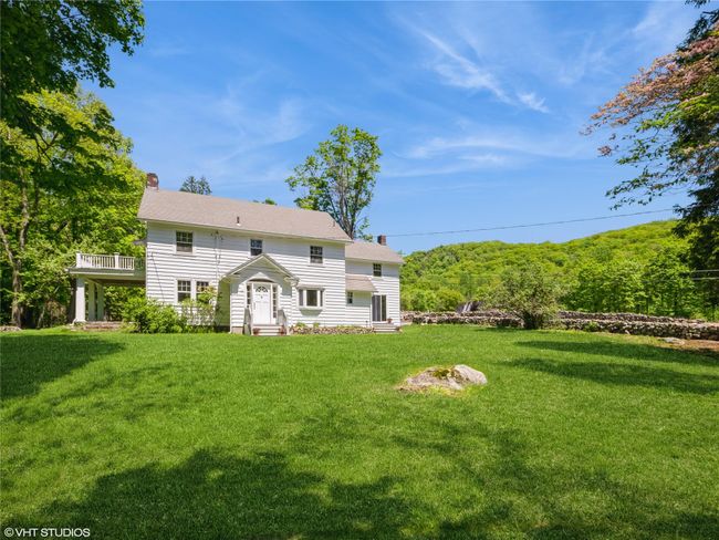 Rear view of property with a chimney, entry steps, a lawn, and a balcony | Image 10