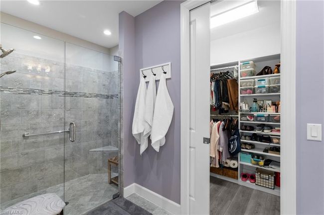 Bathroom featuring a shower stall, a walk in closet, wood finished floors, and recessed lighting | Image 19