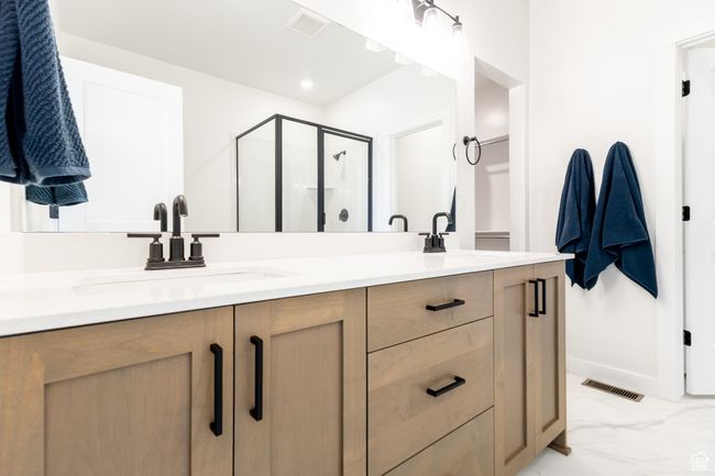 Bathroom featuring double vanity, a stall shower, and marble finish flooring | Image 16