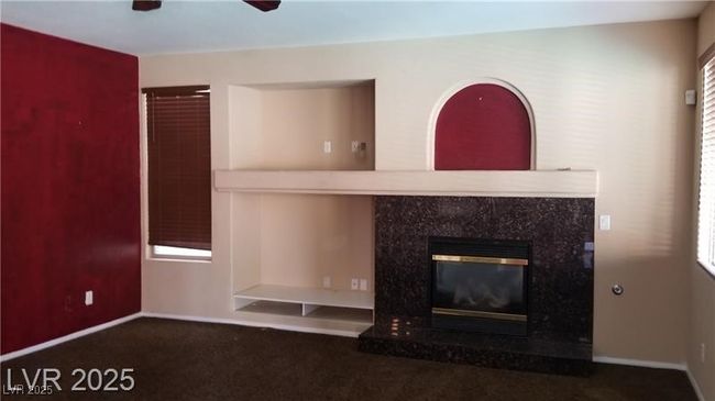 Detailed view of a fireplace, carpet floors, and ceiling fan | Image 23