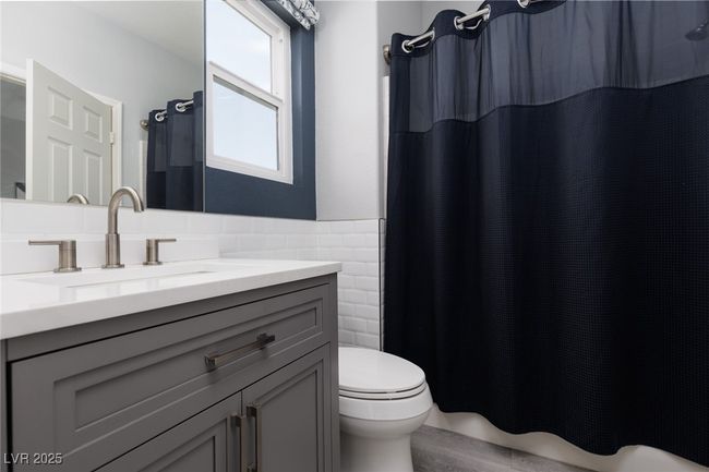 Bathroom featuring tile walls, toilet, vanity, and wood finished floors | Image 18