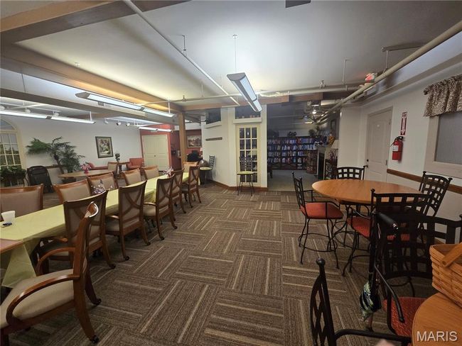 Carpeted dining space and library | Image 26