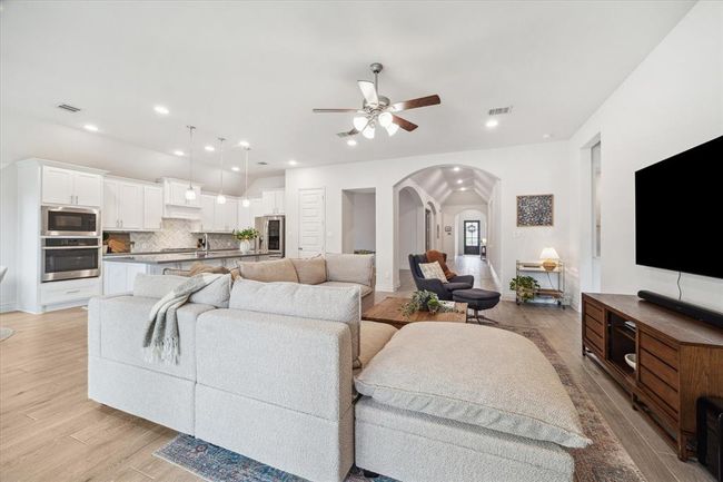 The open family room serves as the ultimate gathering space, seamlessly flowing into the bright morning area and chef’s kitchen, designed to bring everyone together for both everyday living and entertaining. This is a different angle of the space, looking toward the home's entry. | Image 16