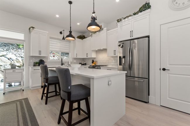 Kitchen featuring stainless steel appliances, tasteful backsplash, white cabinets, and recessed lighting | Image 11