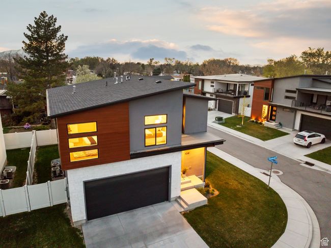 Contemporary home featuring an attached garage, fence, a yard, and concrete driveway | Image 44