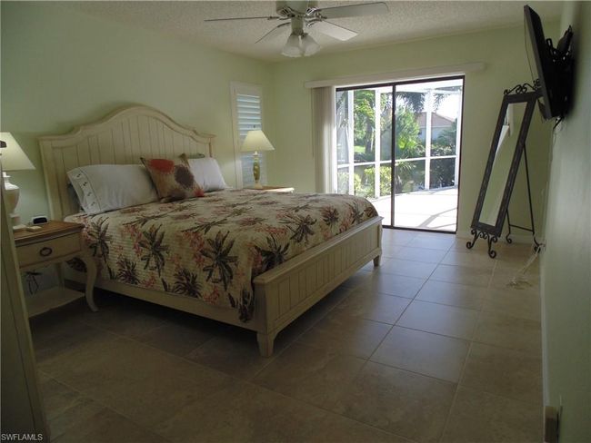 Bedroom with light tile patterned floors, a textured ceiling, ceiling fan, and access to outside | Image 14