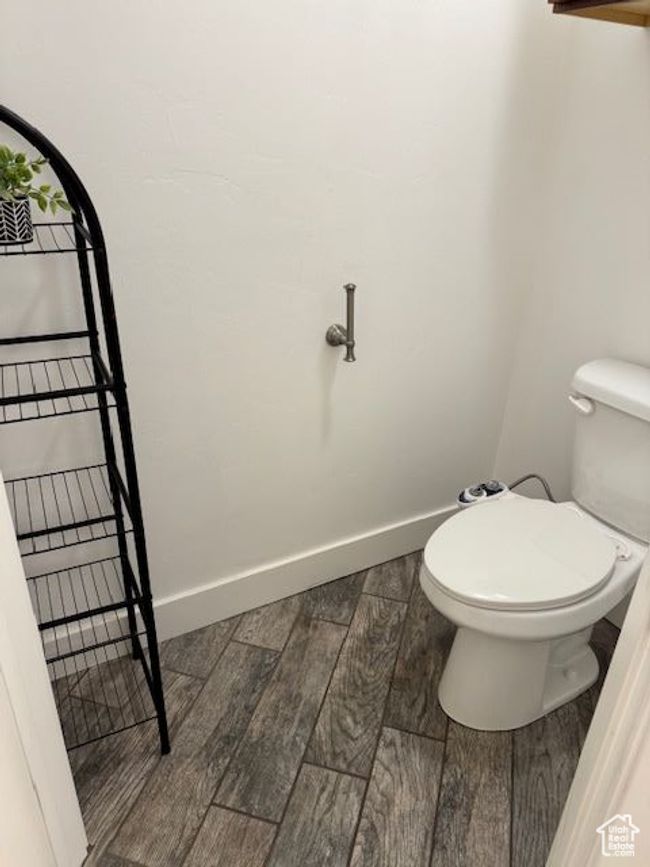 Bathroom featuring wood tiled floor, baseboards, and toilet | Image 21